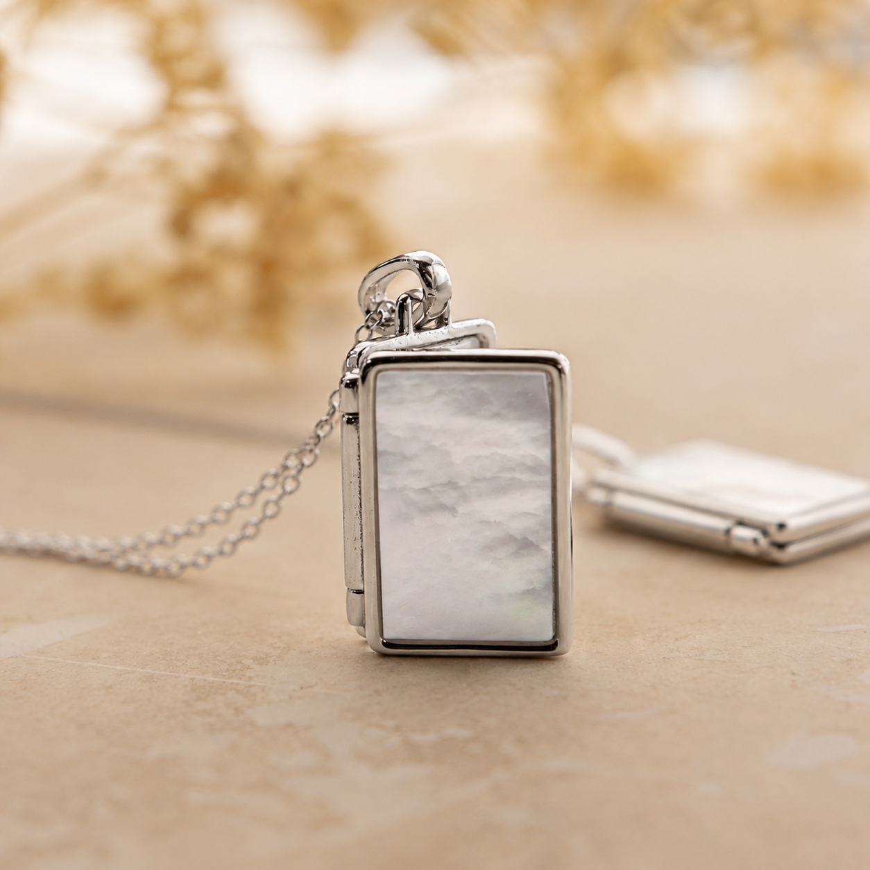 Silver pendant with a marble-like design on a wooden surface
